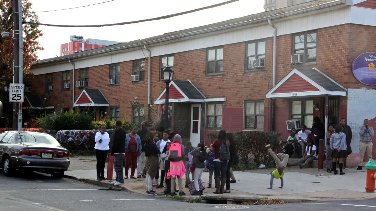 Norris Homes residents gather on the corner of 10th and Norris streets for the dedication of Norris Homes Historical Marker, a mural by Jennie Shanker. (Emma Lee/WHYY)