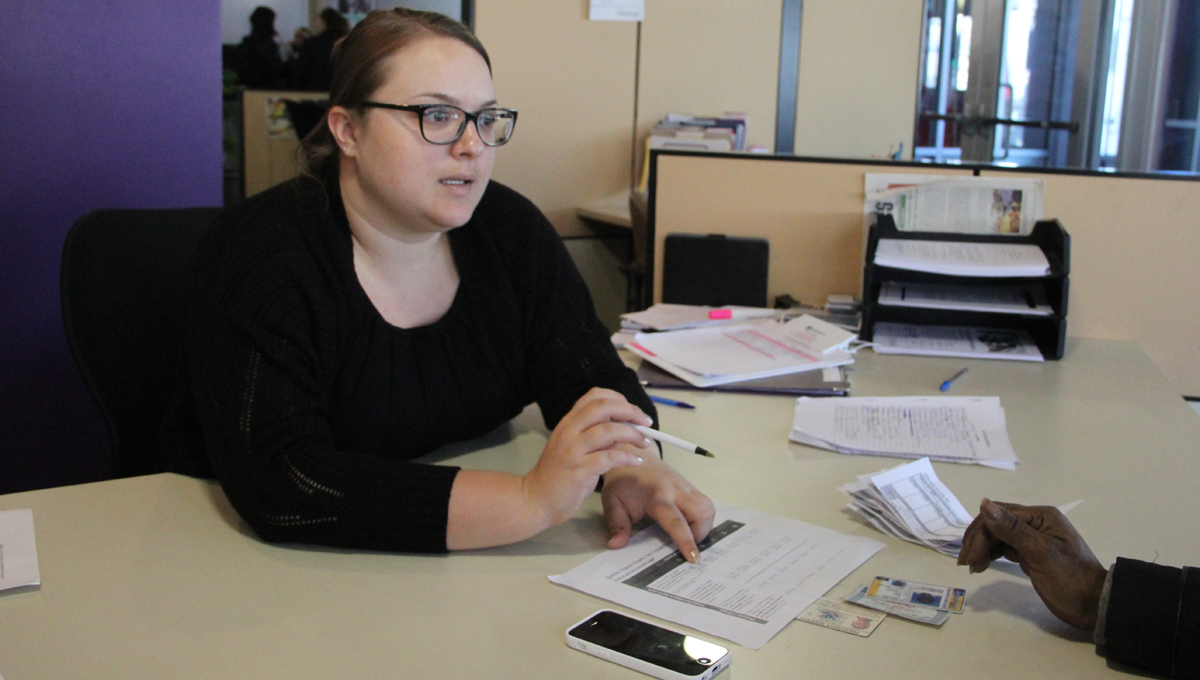  Judith Ferguson, administrative manager at Congreso, reviews the rules of eligibility for coverage under the Affordable Care Act with a client. (Emma Lee/for NewsWorks) 