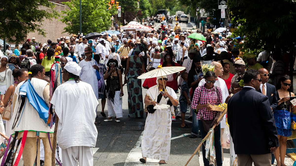 The procession nears its destination, the South Street Bridge, where in the Yoruba tradition, people will make an offering of fruit and flowers to Oshun, the goddess of the river. (Brad Larrison/for NewsWorks)