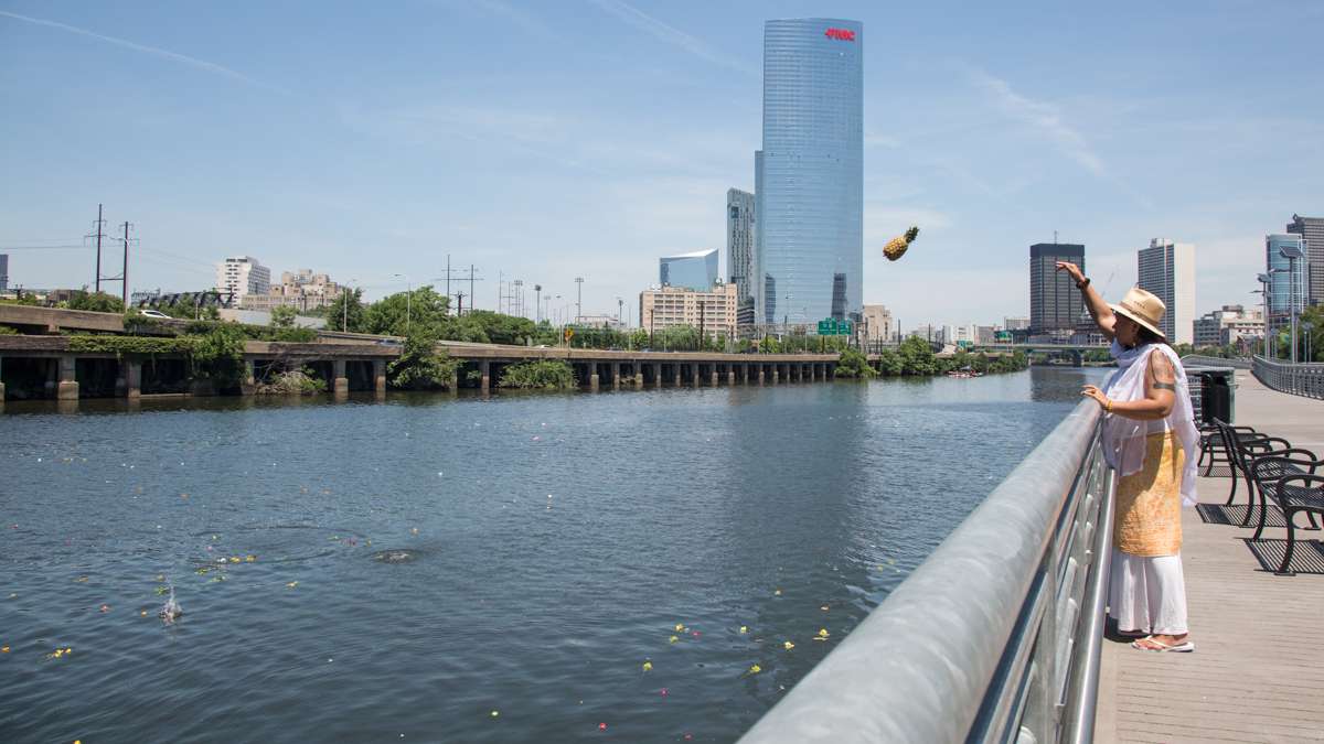 Alisha Wiley, from Mount Airy, tosses her offering to Oshun, the Yoruba river goddess, into the Schuylkill River at the begining of the Philadelphia Odunde Festival.