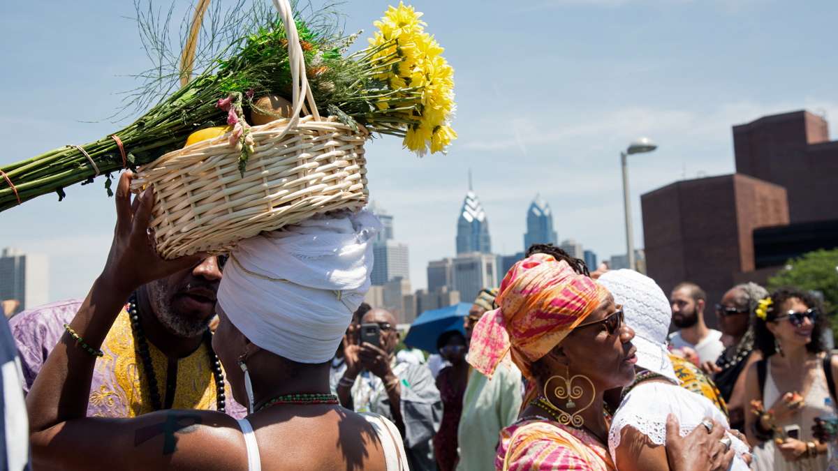 A woman carries offerings for the river goddess Oshun at the begining of the Philadelphia Odunde Festival.
