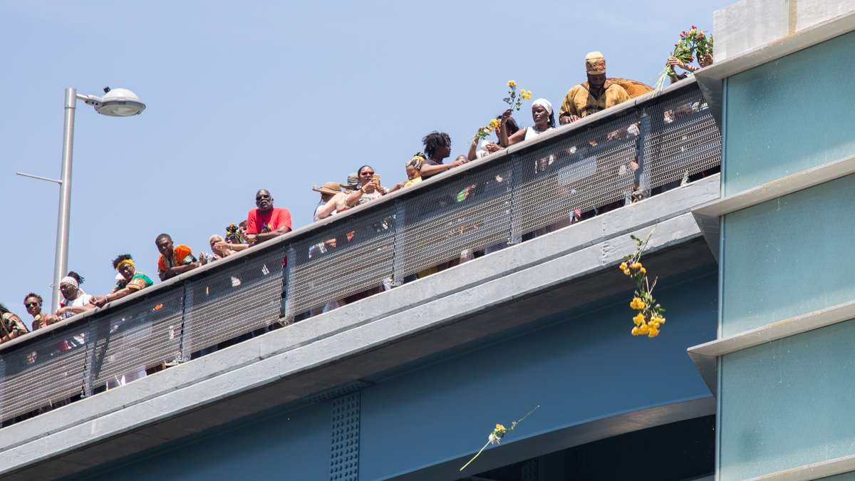Celebrants toss fruit and honey into the Schuylkill River as an offering to Oshun, the Yoruba river goddess, to start the Philadelphia Odunde Festival.