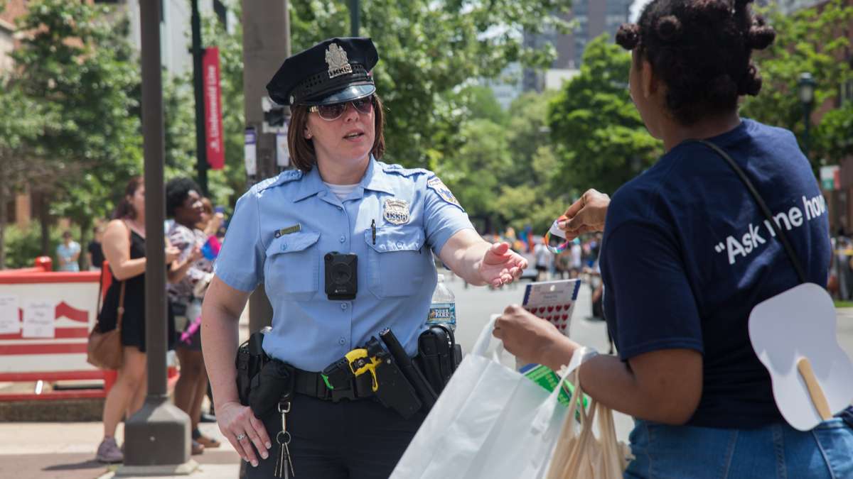 A marcher gives a Philadelphia police officer a pride bracelet at the 2017 Philadelphia Pride Parade, Sunday, June 18, 2017.