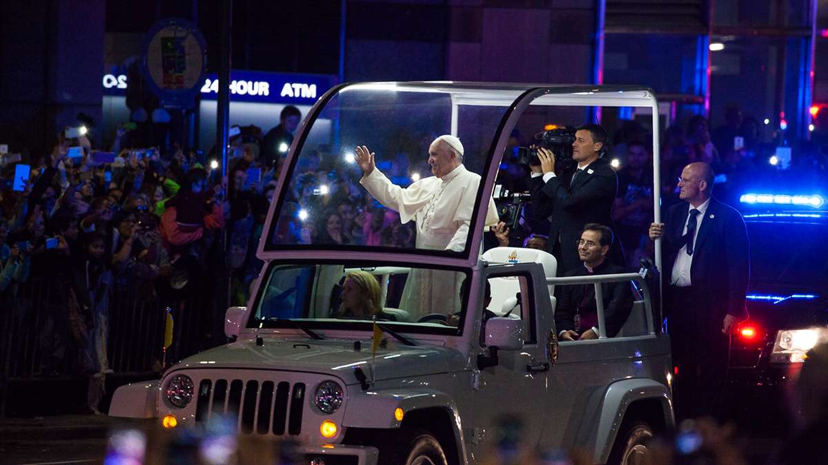 Festival of Families: Pope Francis waves to the crowd at 15th and JFK Boulevard during Saturday's parade. (Brad  Larrison/for NewsWorks)