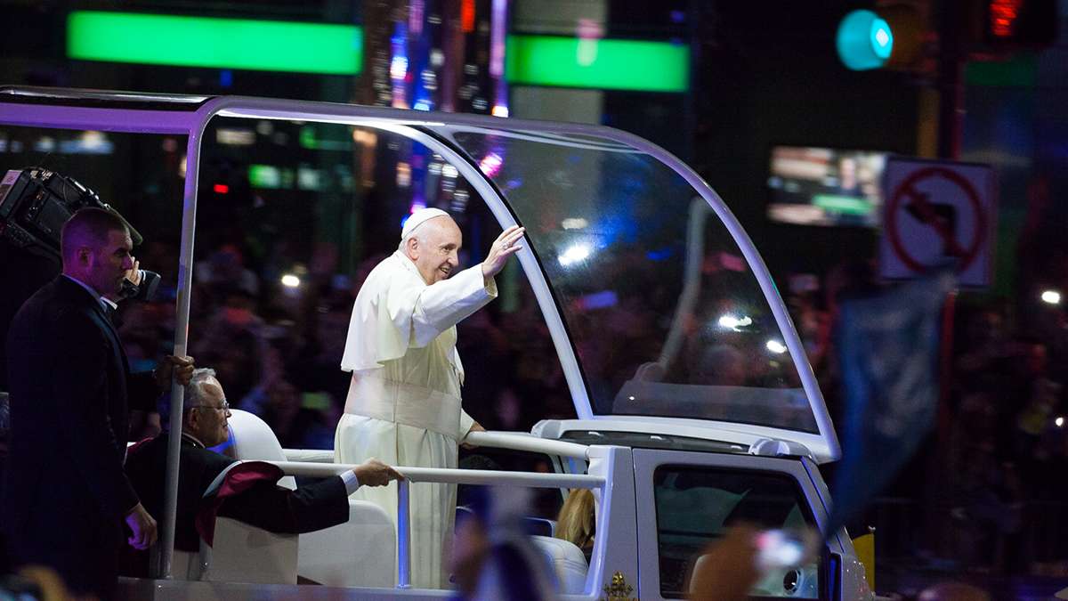 Festival of Families: Pope Francis waves to the crowd at 15th and JFK Boulevard during Saturday's parade. (Brad  Larrison/for NewsWorks)