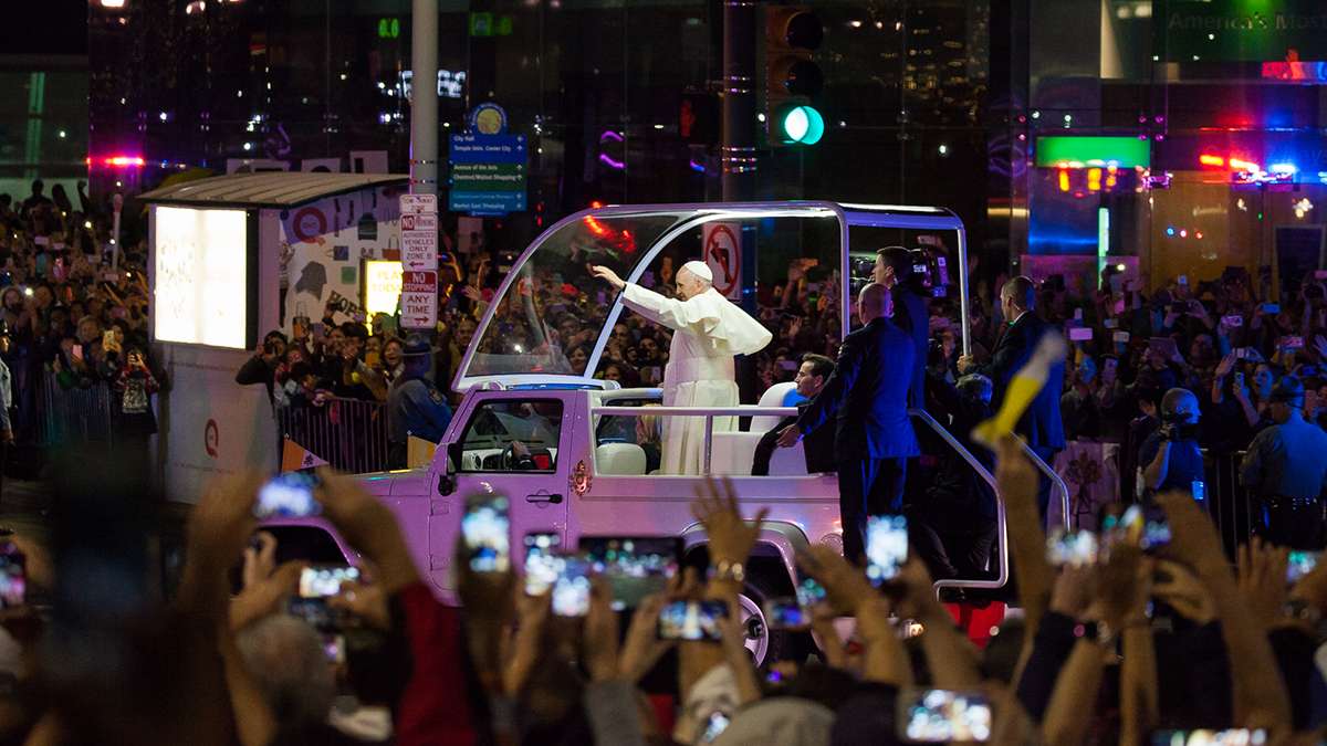 Festival of Families: Pope Francis waves to the crowd at 15th and JFK Boulevard during Saturday's parade. (Brad  Larrison/for NewsWorks)