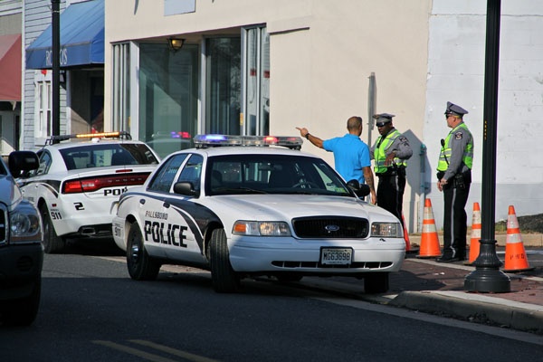 <p>Paulsboro police on Delaware Avenue keep residents and business owners away from a 12-block area evacuated because of a chemical spill from a derailed train. (Emma Lee/for NewsWorks)</p>

