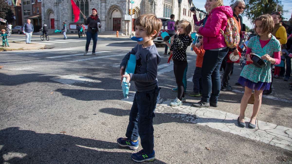 Kids from Children's Community School join the parade halfway through the route with noise makers. (Emily Cohen for NewsWorks)