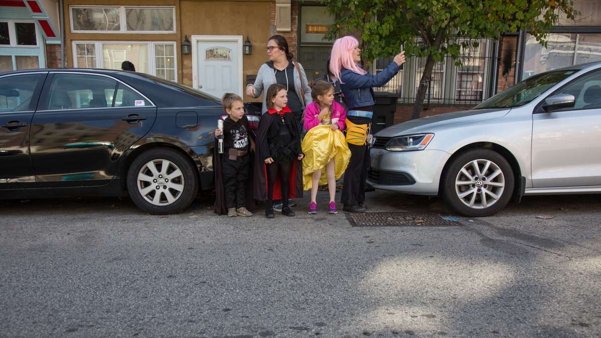 Community members watch as the 17th annual Peoplehood parade passes through their neighborhood in West Philadelphia, Oct. 29, 2016.