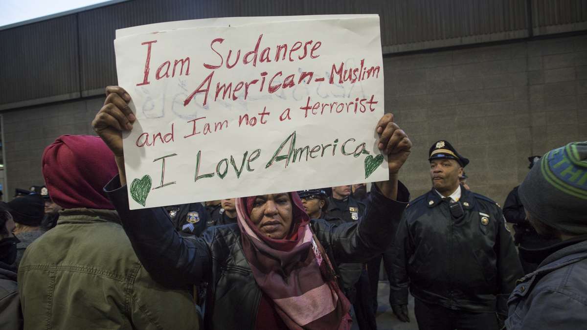 Sudanese immigrant Wisal Abdelal holds a sign protesting Donald Trump’s executive order on immigration outside of Philadelphia International Airport. (Branden Eastwood for NewsWorks) 
