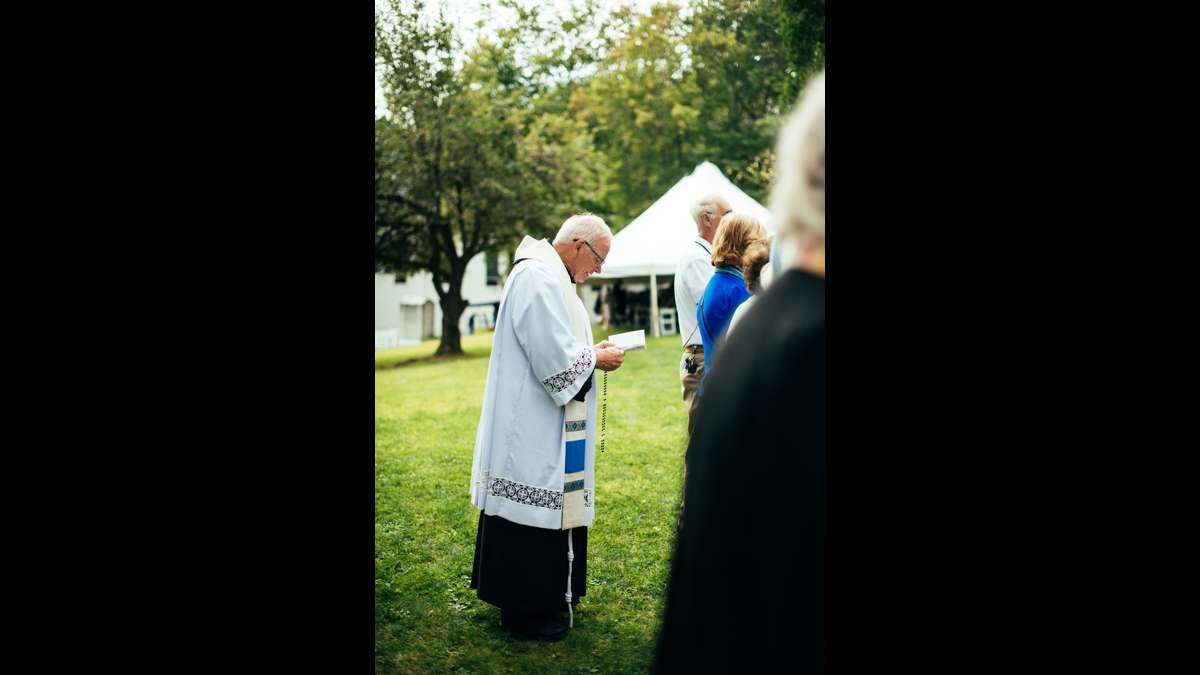 Father Martin Kobos prays a Living Rosary while holding his own Rosary given to him by Pope John Paul II.