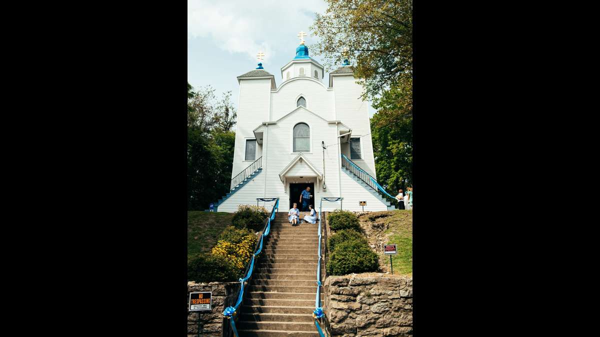 Sister Susan Mary and Sister Anna sit on the steps of the Assumption of the Blessed Virgin Mary.