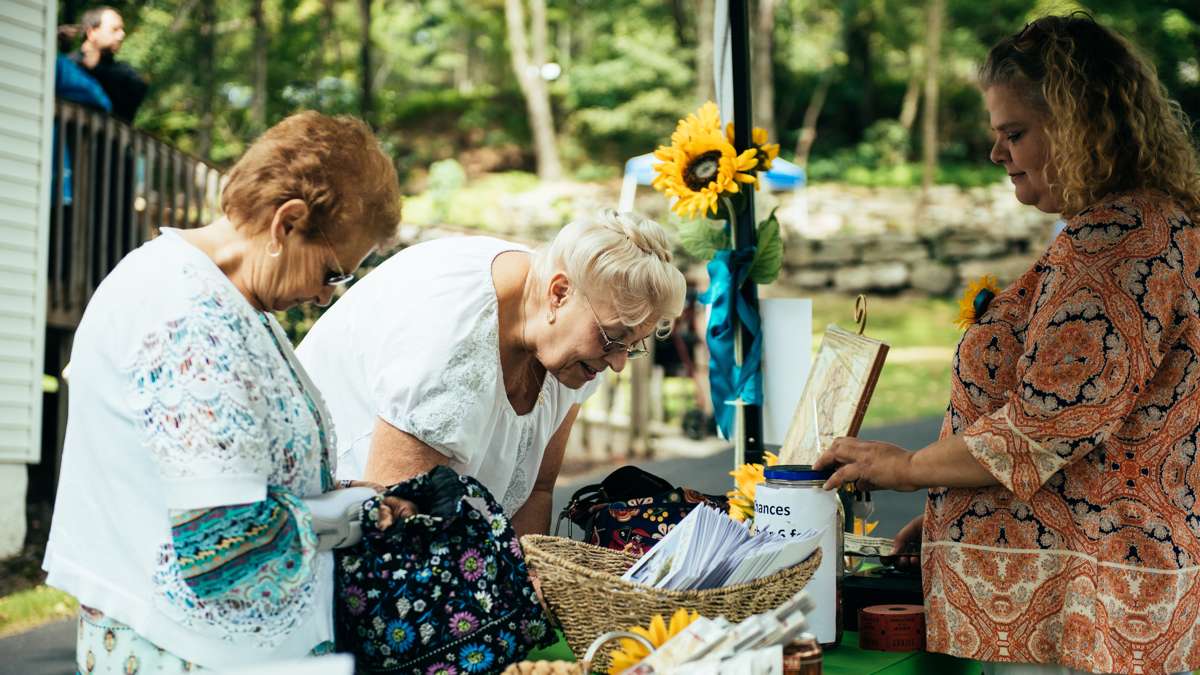 Ellen Hitchens (left) and Joanne Timbario (middle) fill out raffle tickets collected by Petrina Bertel to benefit the Pilgrimage.