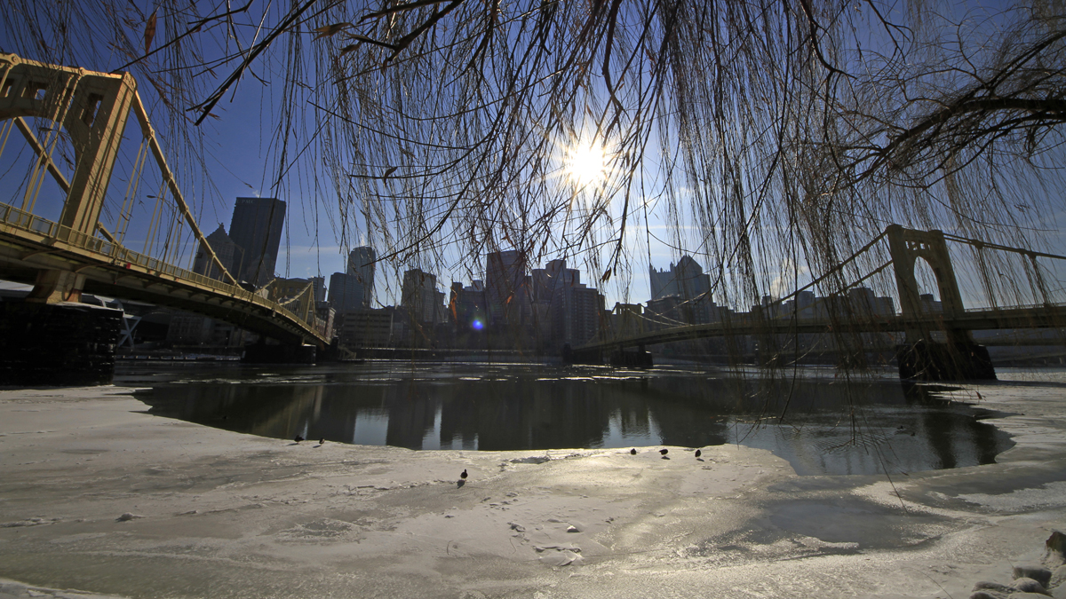  The sun hangs over the skyline of downtown Pittsburgh, beginning to melt the ice on the Allegheny river. (AP Photo/Gene J. Puskar) 