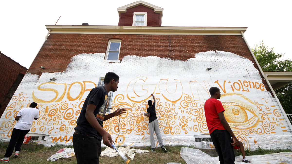  Young adult artists in the Homewood section of Pittsburgh paint a mural on the side of a building as part of a community wide 10 mural project organized by Moving the Lives through its Community Mural Project Wednesday, July 13, 2016. (AP Photo/Gene J. Puskar) 