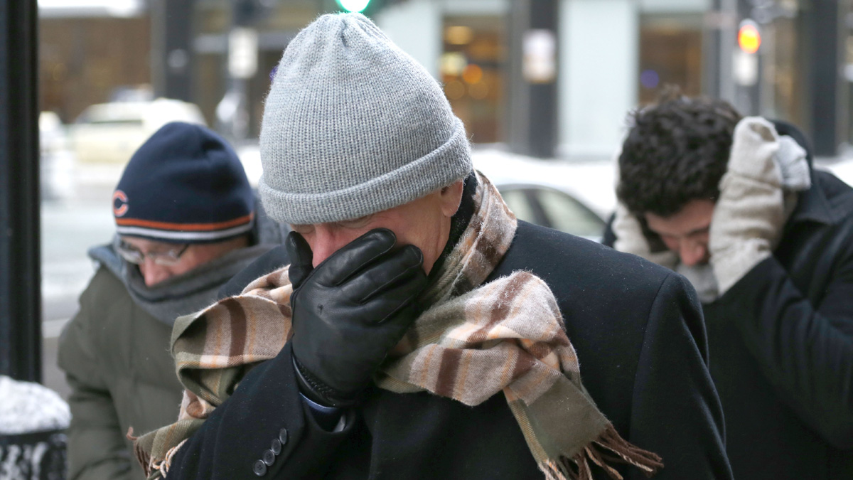  Three men protect themselves from the elements as they walk in Chicago's Loop with temperatures well below zero. A whirlpool of frigid, dense air known as a 