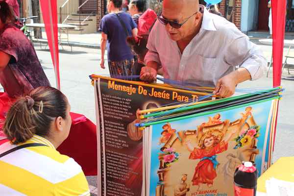 I caught up with this man as he walked the length of the festival peddling colorful posters targeted to any religious belief preference.  When the vendor ran out of posters, he switched to selling Latino themed t-shirts. Real entrepreneur!  (Elisabeth Perez-Luna/WHYY)