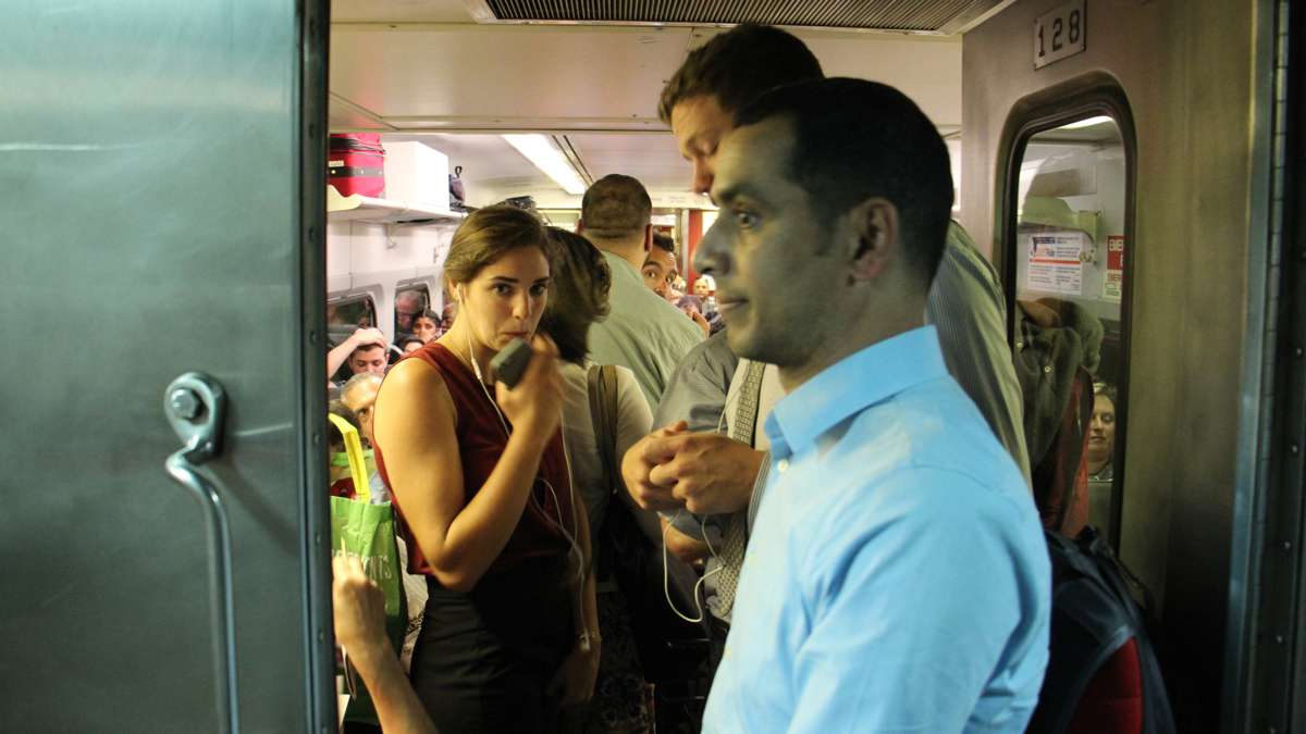 Passengers spill into the vestibule of a crowded regional rail car at Suburban Station during the evening commute. (Emma Lee/WHYY)