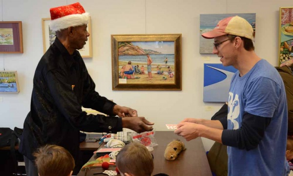 <p><p>Lamont Samuel, also known as Mr. Magic, entertains attendants with a simple card trick on Saturday afternoon at the Roxborough Development Corporation's children's party. (Jimmy Viola/for NewsWorks)</p></p>
