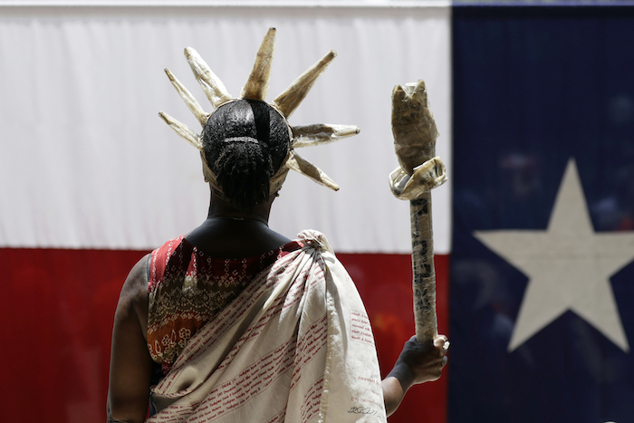 a protester dressed as the Statue of Liberty