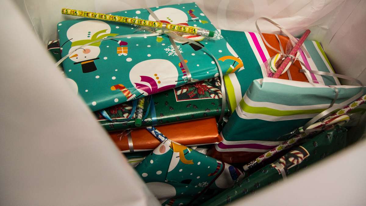 Each student at Richard Wright elementary school receives a book, candy cane, and pencil donated from suburban parents.