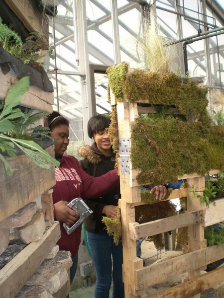 <p><p>Juniors Khandace Hampton and Taylor Gibson arrange moss for the "Tee Time" wall. (Carrie Hagen/for NewsWorks)</p></p>
