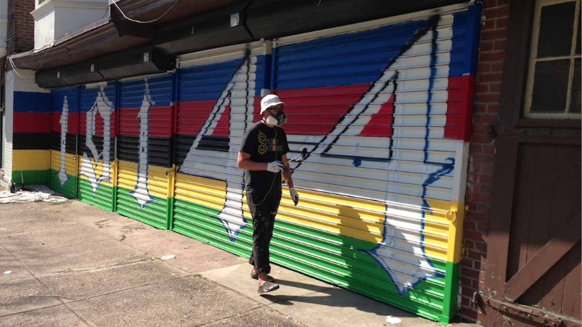 Tim Walkiewicz paints the outside of the yet-opened Coulter Street Supply Co. espresso bar. (Brian Hickey/WHYY) 