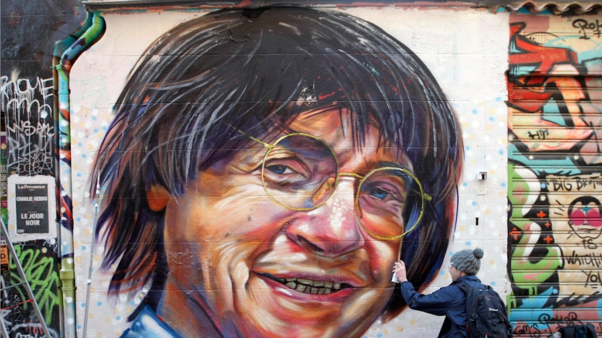  The artist Julien paints a portrait of the French cartoonist Jean Cabut, also known as Cabu, as a tribute to him, in Marseille, southern France, Friday Jan. 9, 2015. Masked gunmen stormed the offices of a satirical newspaper Charlie-Hebdo Wednesday, and killed 12 people: eight journalists, including Cabu, two police officers, a maintenance worker and a visitor were killed in the attack. (AP Photo/Claude Paris) 
