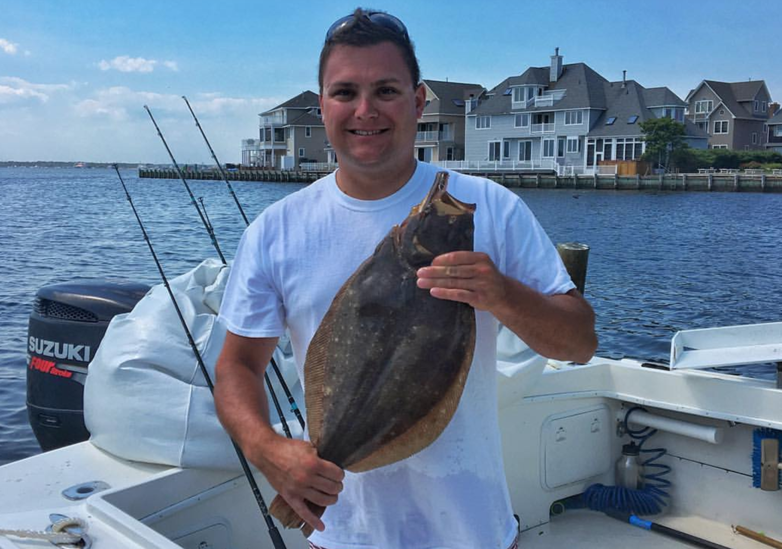  Angler Andrew Pero holds up a summer flounder after arriving back at port in South Seaside Park in August 2016.  