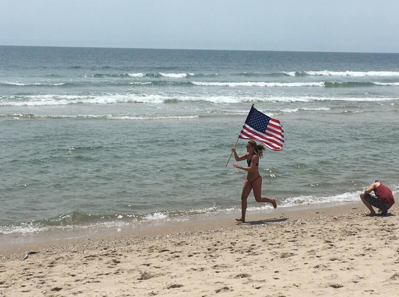  A lifeguard runs the American flag along the shoreline in Long Beach Island. (Image courtesy of Bobby Lynch/Brant Beach Surf Rescue) 