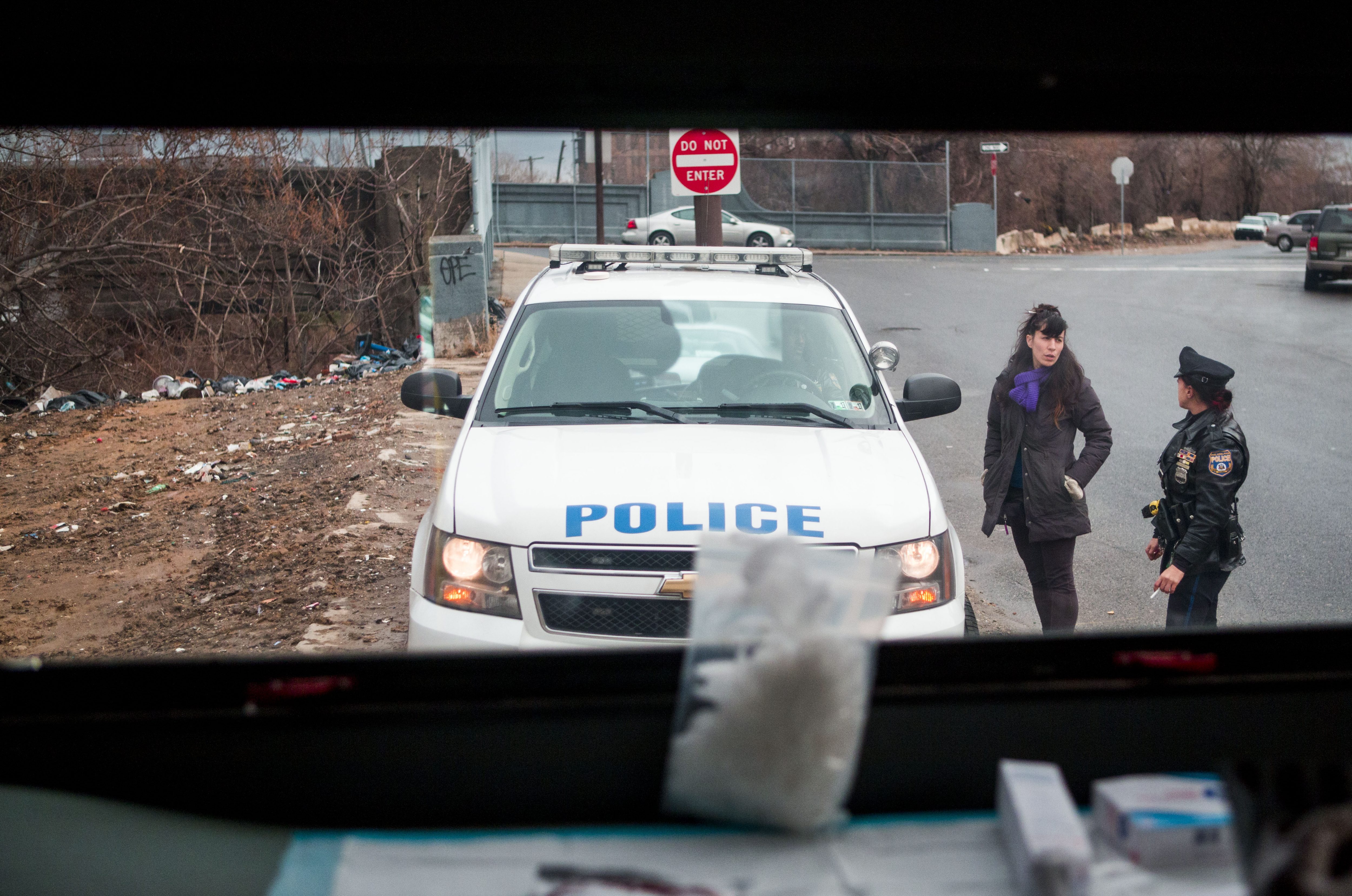 Sheila Dhand (center) speaks to Philadelphia police officers after she had administered Narcan to a man overdosing in Kensington. (Jessica Kourkounis/For Keystone Crossroads)