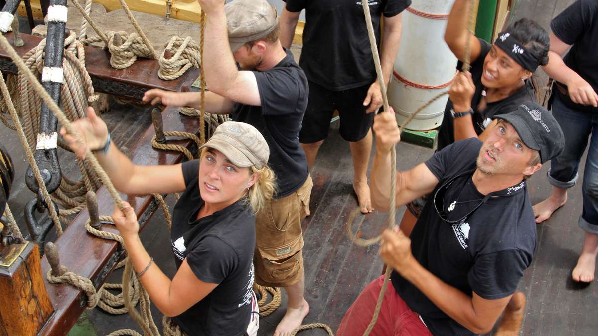 Crew members haul up sails as the Picton Castle leads the Parade of Ships at the Tall Ships Festival. (Emma Lee/WHYY)