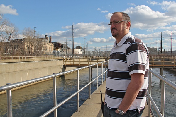 <p>Anthony DiGironimo, a manager at the Northeast Philadelphia sewage treatment plant, watches as swallows hunt for midges above the effluent tanks. (Emma Lee/for NewsWorks)</p>
