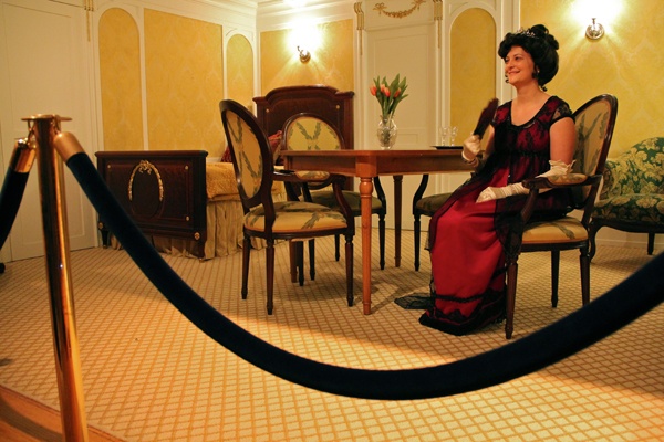 Franklin Institute volunteer Karen Knodel portrays the Countess of Roth sitting in the recreation of a first class cabin. (Emma Lee/for NewsWorks)