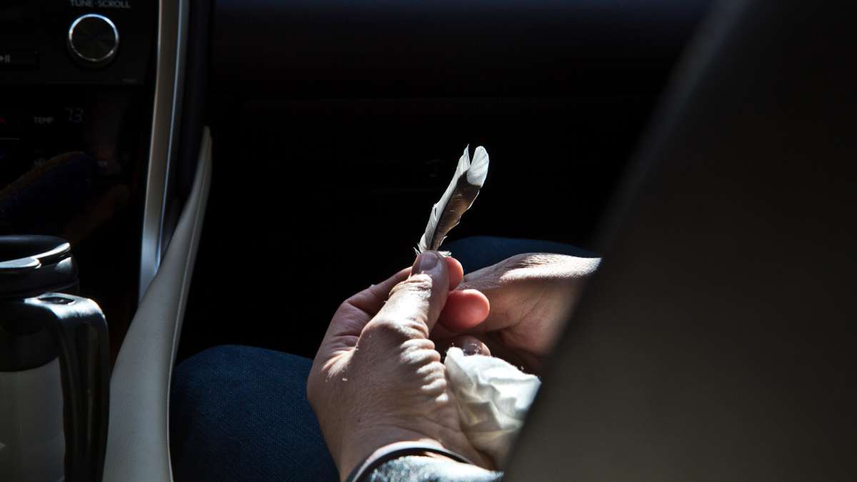 Dianne Valiante holds a feather she found visiting the tracks where her daughter was killed.