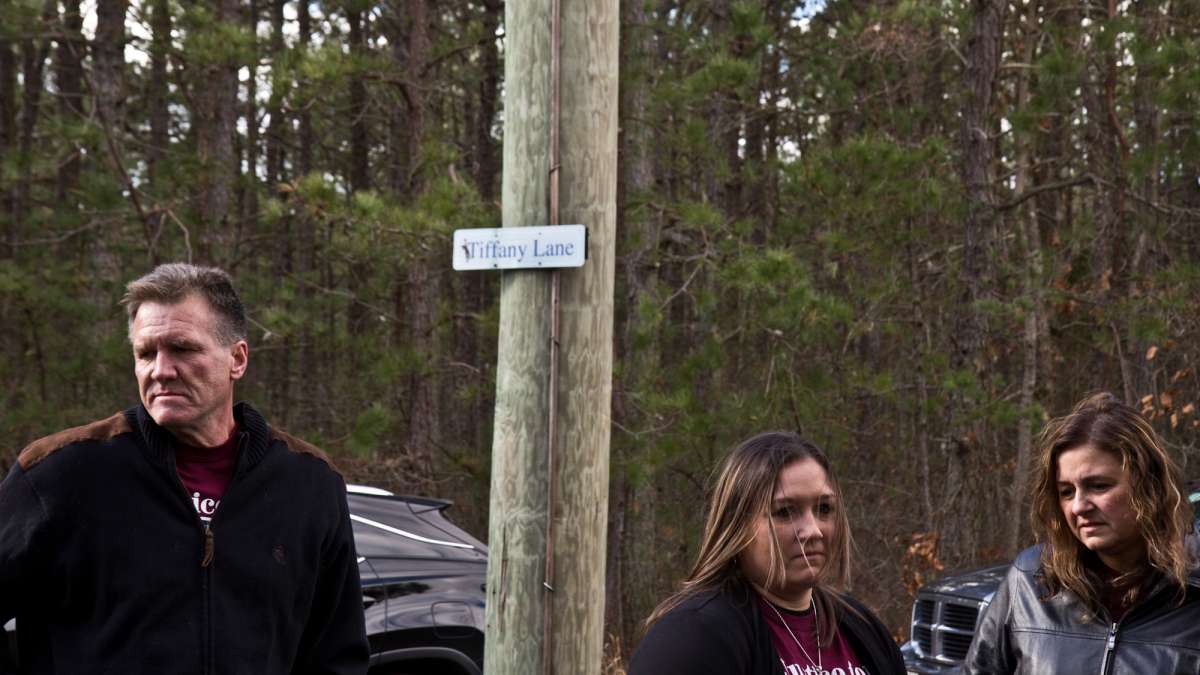 Tiffany’s father Stephen Valiante, sister Krystal Summerville, and mother Dianne Valiante stand beneath a sign commemorating Tiffany near the tracks where she was fatally struck.