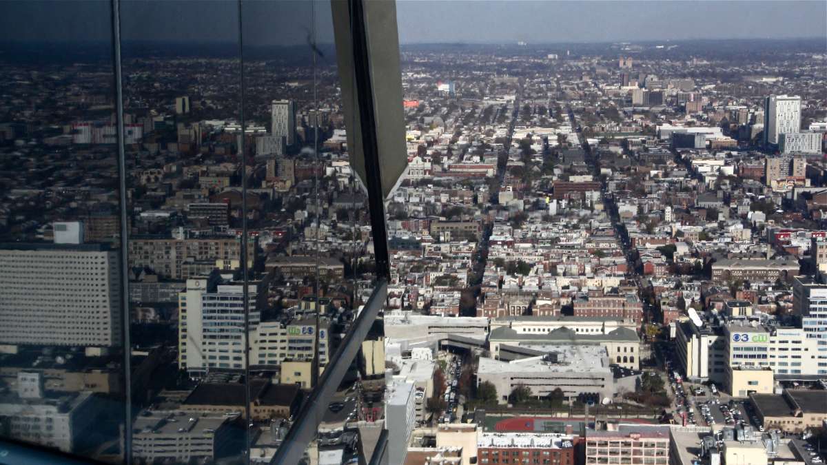 The view north is reflected in the glass of One Liberty Place.