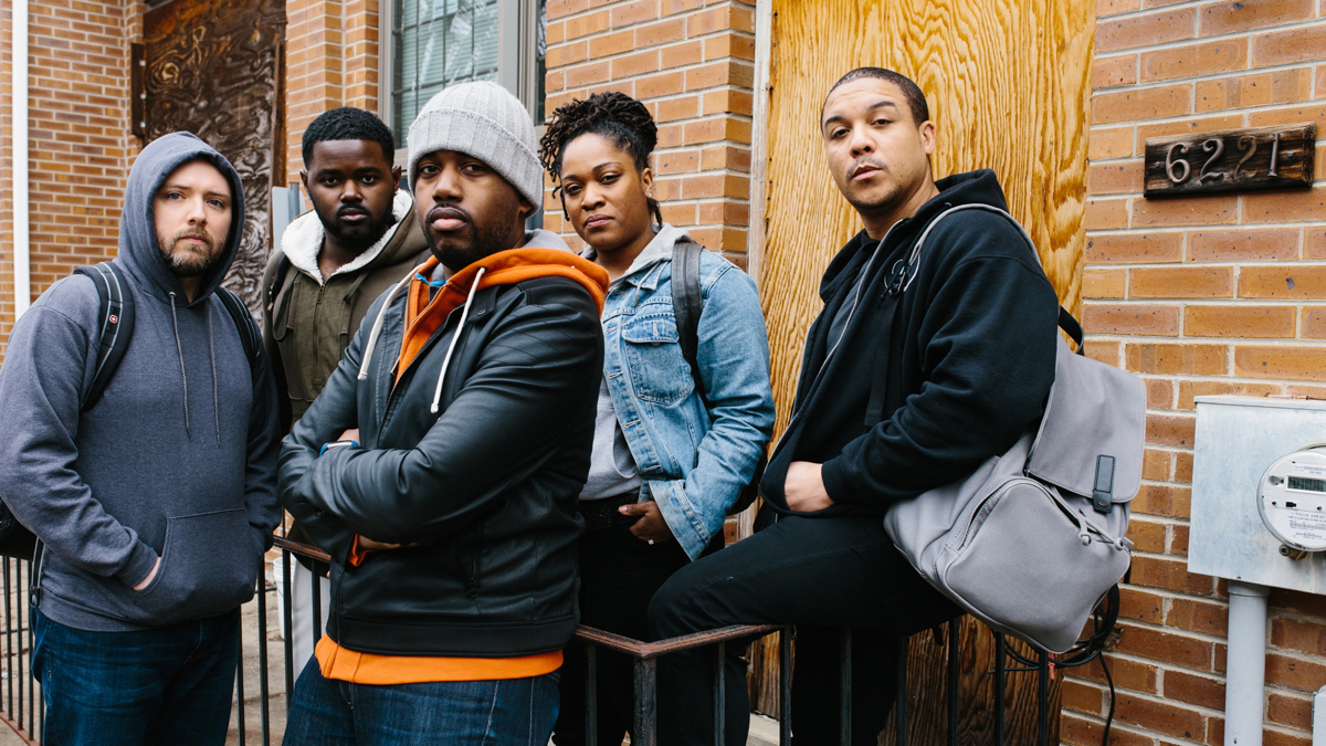  The cast of ''We Shall Not Be Moved,'' (from left) John Little (tenor Daniel Shirley), John Blue (countertenor John Holiday), John Mack (baritone Adam Richardson), Un/Sung (spoken word artist Lauren Whitehead), and John Henry (bass-baritone Aubrey Allicock) stand in front of the boarded-up Osage Avenue home on the site of the 1985 MOVE bombing in Philadelphia. (Dominic M. Mercier for Opera Philadelphia) 