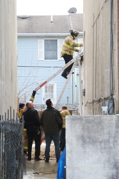 <p>Wilm police and firefighters check roof tops @ 2pm monday on Peach st. for weapons and evidence. (John Jankowski/for NewsWorks)</p>
