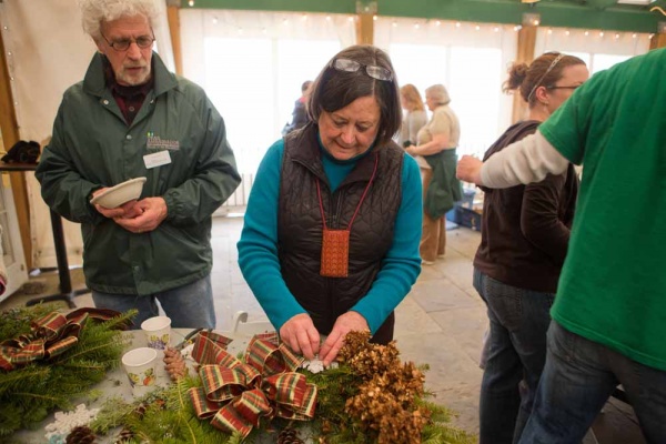 <p><p>Friends of the Wissahickon Trail Ambassador Don Simon watches as Suzanne Zimmermann afixes a snowflake to her wreath at the Winter in the Wissahickon event. (Dave Tavani/for NewsWorks)</p></p>
