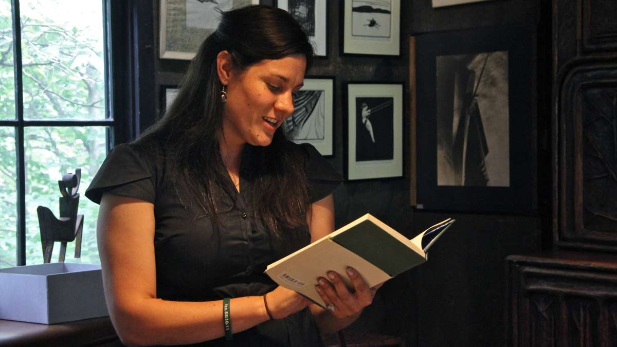 Curator Laura Heemer reads from a freshly minted copy of Rhymes of Early Jungle Folk at the Wharton Esherick Museum in Paoli. (Emma Lee/WHYY)