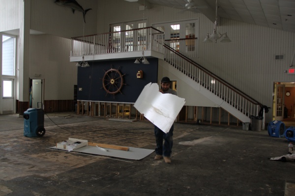 <p>Ed Colavita helps to clear out the Ocean City Yacht Club which was inundated by Hurricane Sandy. Voters who usually vote at the club were sent to a nearby church. (Emma  Lee/for NewsWorks)</p>
