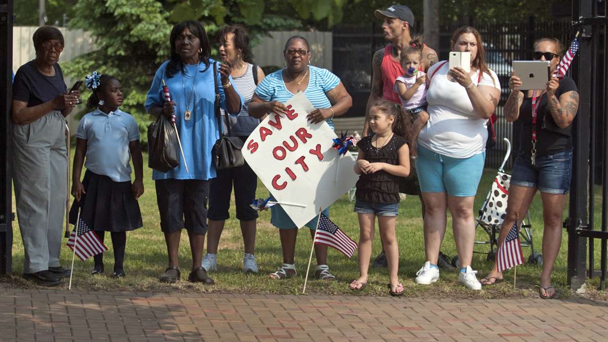  A crowd watches as President Barack Obama's motorcade travels on Harrison Avenue after he spoke at the Ray & Joan Kroc Corps Community Center in Camden, N.J. (Chris LaChall/Camden Courier-Post via AP, Pool) 