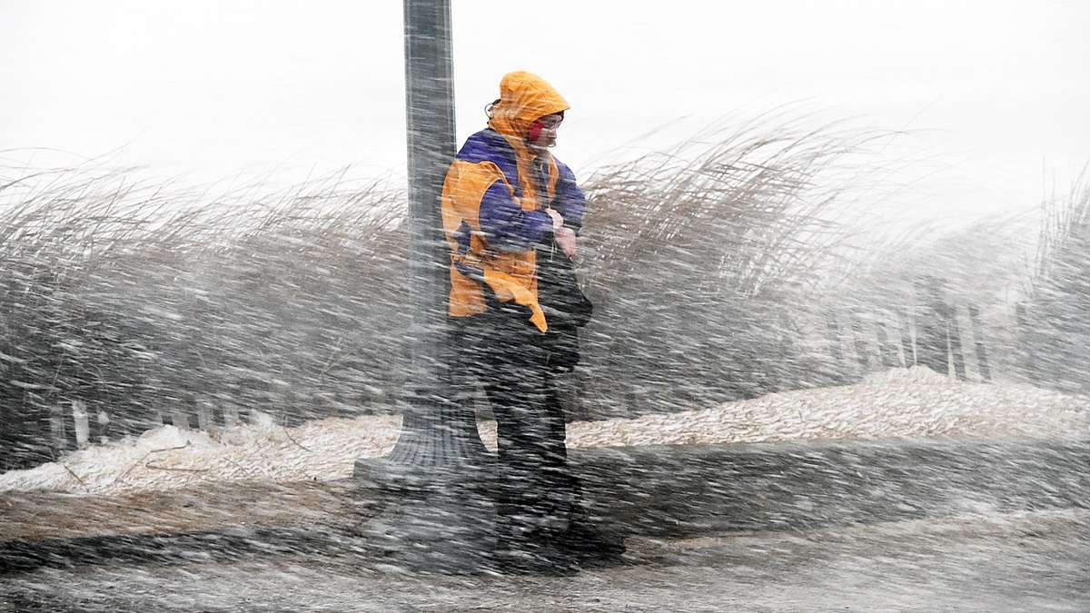 A major winter storm in late January dumps one to two feet of snow and causes coastal flooding in New Jersey and Delaware. One brave soul braces against the wind near the dunes in Rehoboth. (Chuck Snyder/for NewsWorks)