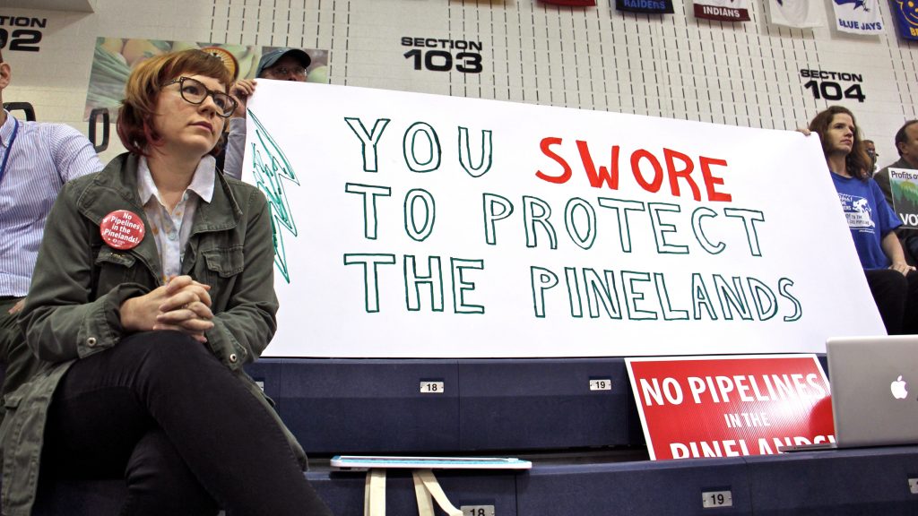 2017-07-26-e-lee-toms-river-pine-belt-arena-pinelands-commission-public-hearing-pipeline-njng-srl-2 Protesters armed with signs fill the bleachers at Pine Belt Arena in Toms River, where the New Jersey Pinelands Commission held a public hearing on the Southern Reliability pipeline through Burlington and Ocean counties. (Emma Lee/WHYY, file)
