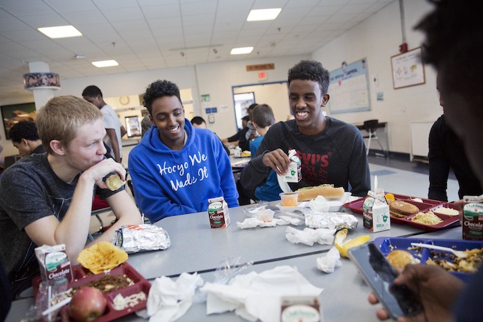 Abdiaziz Shaleh,Essa Gedi,Isiah Leach Abdiaziz Shaleh, right, a Lewiston high school senior and co-captain of the soccer team, and Essa Gedi, center, both whose families emigrated from Somalia, sit with classmate Isiah Leach, left, during lunch in the school's cafeteria in Lewiston, Maine, Wednesday, March 15, 2017. Two years ago, immigrant children led the high school soccer team to win the state championship, a moment heralded as a triumph for the city's embrace of its immigrant community. (AP Photo/David Goldman)