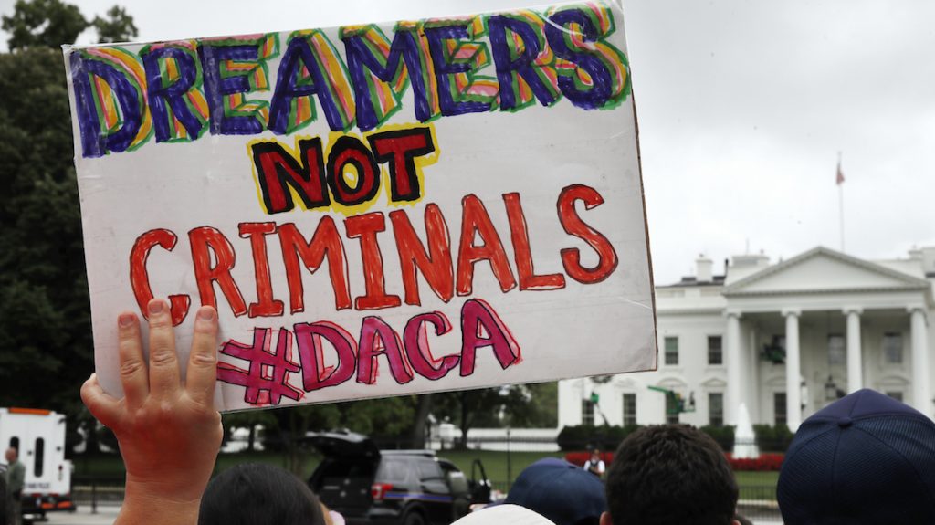 ap_17240009020124 FILE- In this Aug. 15, 2017, file photo, a woman holds up a signs in support of the Obama administration program known as Deferred Action for Childhood Arrivals, or DACA, during an immigration reform rally at the White House in Washington. (AP Photo/Jacquelyn Martin, File)