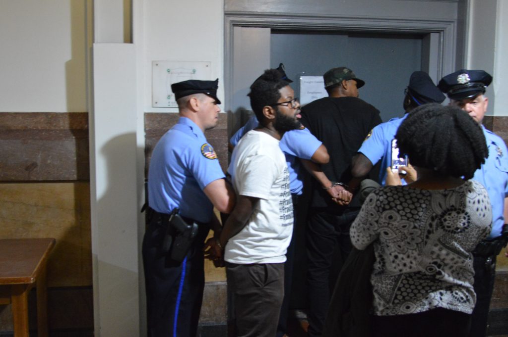 cuffs-1 Two of the protesters are put on a freight elevator at City Hall after being removed from Council chambers. (Tom MacDonald/WHYY)