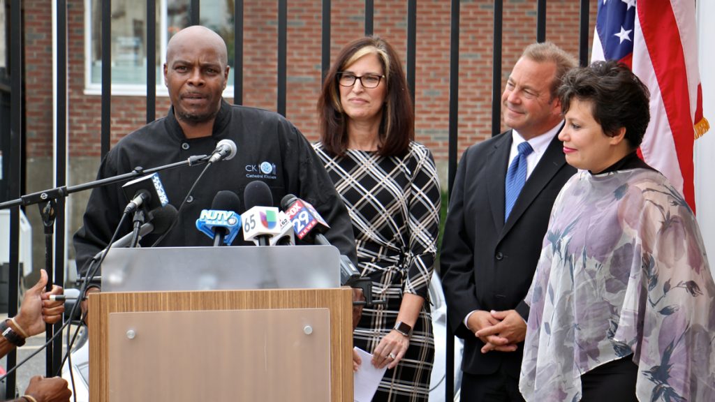  Mark Woodall (left), a former state prison inmate and current chef at Cathedral Kitchen, talks about the difficulty of finding permanent shelter during re-entry. With him are (from right) Camden County Freeholder Carmen Rodriguez, Freeholder Director Louis Cappelli Jr., and Volunteers of America Chief Operating Officer Pat McKernan, who announced a new plan to end homelessness. (Emma Lee/WHYY) 