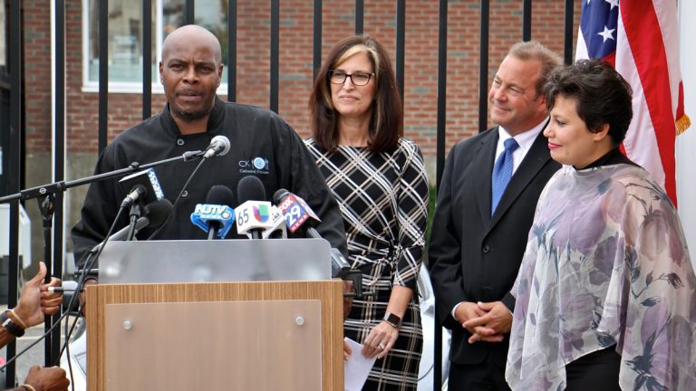  Mark Woodall (left), a former state prison inmate and current chef at Cathedral Kitchen, talks about the difficulty of finding permanent shelter during re-entry. With him are (from right) Camden County Freeholder Carmen Rodriguez, Freeholder Director Louis Cappelli Jr., and Volunteers of America Chief Operating Officer Pat McKernan, who announced a new plan to end homelessness. (Emma Lee/WHYY) 
